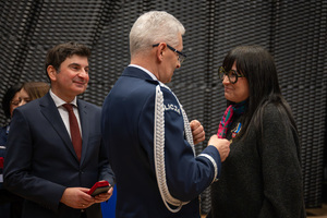 Na zdjęciu Komendant Wojewódzki Policji w Katowicach przypinający medal pracownicy