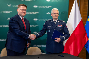 Na zdjęciu Komendant Wojewódzki Policji w Katowicach z mężczyzna podający sobie dłonie po podpisaniu porozumienia.