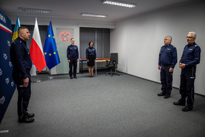Na zdjęciu czterech policjantów i policjantka stojący w sali