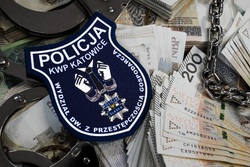 Na zdjęciu widać naszywkę z napisem KWP Katowice Wydział do Walki z Przestępczością Gospodarczą koloru granatowego położoną na banknotach i kajdankach.