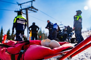 Na zdjęciu manekin na czerwonych noszach na stoku