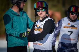 Trzech uczestników zawodów stojących na stoku