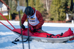 Uczestnik zawodów pochylający sie na saniami