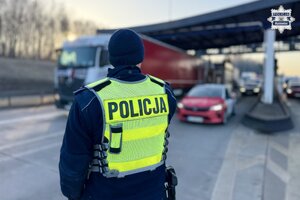 Zdjęcie policjanta stojącego przy autostradzie.