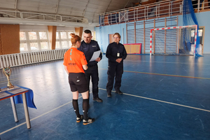 Naczelnik Doboru Kadr i Szkolenia wraz z umundurowaną policjantką wręcz dyplom podziękowania pani sędziujący mecz.