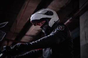 Zbliżenie od boku na motocyklistę siedzącego na motocyklu