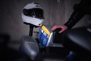 Zbliżenie na tylną część motocykla, widać rękę policjanta dotykającego oparcie pasażera