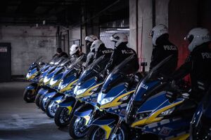 Ustawione w rzędzie motocykle i stojący przy nich policjanci gotowi do jazdy