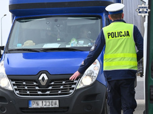 na zdjęciu widzimy umundurowanego policjanta ruchu drogowego zatrzymującego pojazd typu bagażówka marki renault.