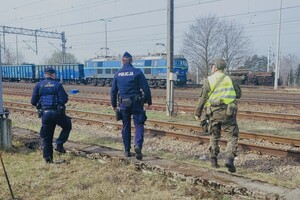 Patrol złożony z dwóch policjantów oraz żołnierza patrolujący torowisko