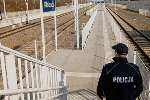 Umundurowany Policjant wchodzący na peron kolejowy