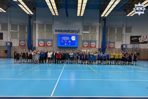 Zdjęcie zbiorowe na hali sportowej przedstawiające koszykarzy