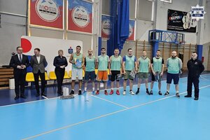 Zdjęcie drużyny piłkarskiej na hali sportowej wraz z organizatorami