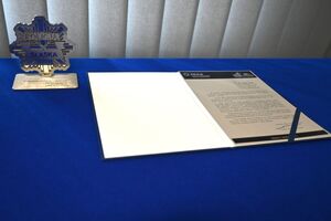na zdjęciu statuetka oraz  teczka z przemówieniem