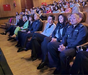 na zdjęciu osoby siedzące na widowni w tym umundurowani policjanci