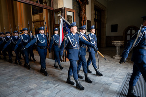na zdjęciu funkcjonariusze policji w mundurach galowych wychodzą z kościoła niosąc sztandar
