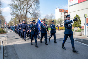 na zdjęciu funkcjonariusze policji maszerujący w mundurach galowych