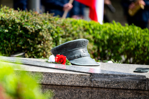 na zdjęciu pomnik z biało-czerwonymi kwiatami