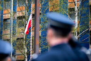 na zdjęciu biało-czerwona flaga na tle Komendy Wojewódzkiej Policji w Katowicach