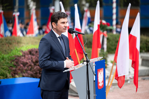 na zdjęciu przemawiający Wojewoda Śląski, w tle flagi biało-czerwone