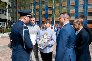 na zdjęciu uczestnicy uroczystości w tym dzieci wręczające upominek funkcjonariuszowi Policji w umundurowaniu galowym