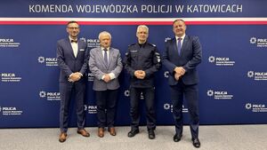 Zdjęcie grupowe uczestników spotkania na tle baneru Komendy Wojewódzkiej Policji w Katowicach