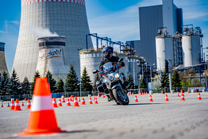 zdjęcie przedstawia policjanta na motocyklu służbowym podczas jednej z konkurencji na torze przeszkód