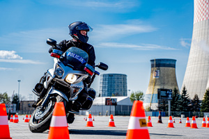 zdjęcie przedstawia policjanta na motocyklu służbowym podczas jednej z konkurencji na torze przeszkód