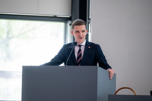 Mężczyzna stoi przy mównicy w auli