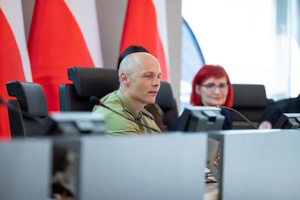 Funkcjonariusz straży granicznej siedzi przy stole konferencyjnym