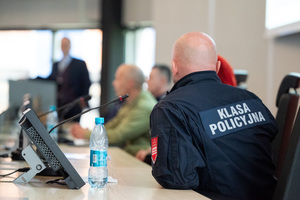 Prelegenci siedzą przy stole konferencyjnym