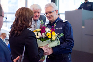 Generał Policji wręcza kwiaty kobiecie