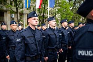 Policjanci w mundurach ćwiczebnych stoją w kilku szeregach