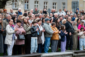 Grupa osób w ubraniach cywilnych, biją brawo