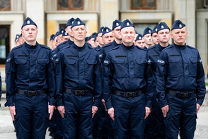 Policjanci w mundurach ćwiczebnych stoją w kilku szeregach