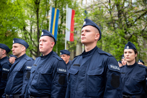 Policjanci w mundurach ćwiczebnych stoją w kilku szeregach