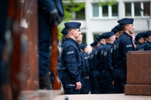 Policjanci w mundurach ćwiczebnych stoją w kilku szeregach