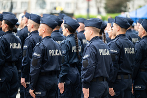 Policjanci i policjantki w mundurach ćwiczebnych stoją w kilku szeregach