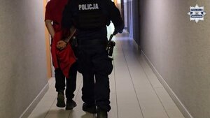 umundurowany policjant prowadzi osobę