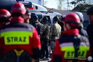 Na zdjęciu funkcjonariusze wchodzący do śmigłowca