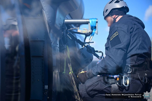 Na zdjęciu funkcjonariusz policji przypinający się liną