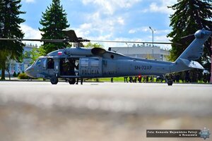 Zdjęcie przedstawia śmigłowiec Black Hawk w tle funkcjonariuszy