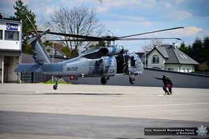 Zdjęcie przedstawia śmigłowiec Black Hawk obok niego policjanci