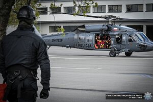 na pierwszym planie śmigłowiec Black Hawk ze strażakami na pokładzie