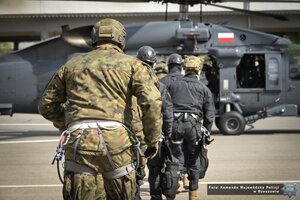 Zdjęcie przedstawia funkcjonariuszy wbiegających do śmigłowca