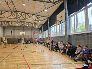 Zdjęcie przedstawia halę gimnastyczną z torem przeszkód po prawej stronie siedzą uczniowie kibicujący