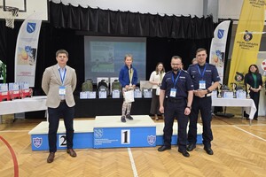 Na zdjęciu uczestniczka turnieju stojąca na podium oraz po obu jej stronach stoją jury