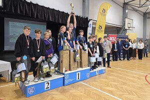 Zdjęcie przedstawia drużyny zwycięzców stojących na podium
