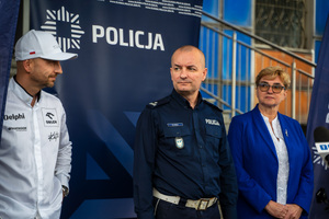 Zdjęcie policjantów, zaproszonych gości oraz dziennikarzy przed budynkiem komendy podczas briefingu