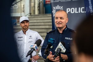 Zdjęcie naczelnika, zaproszonych gości oraz dziennikarzy przed budynkiem komendy podczas briefingu